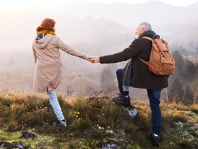 senior couple holding hands while hiking fixed indexed annuity